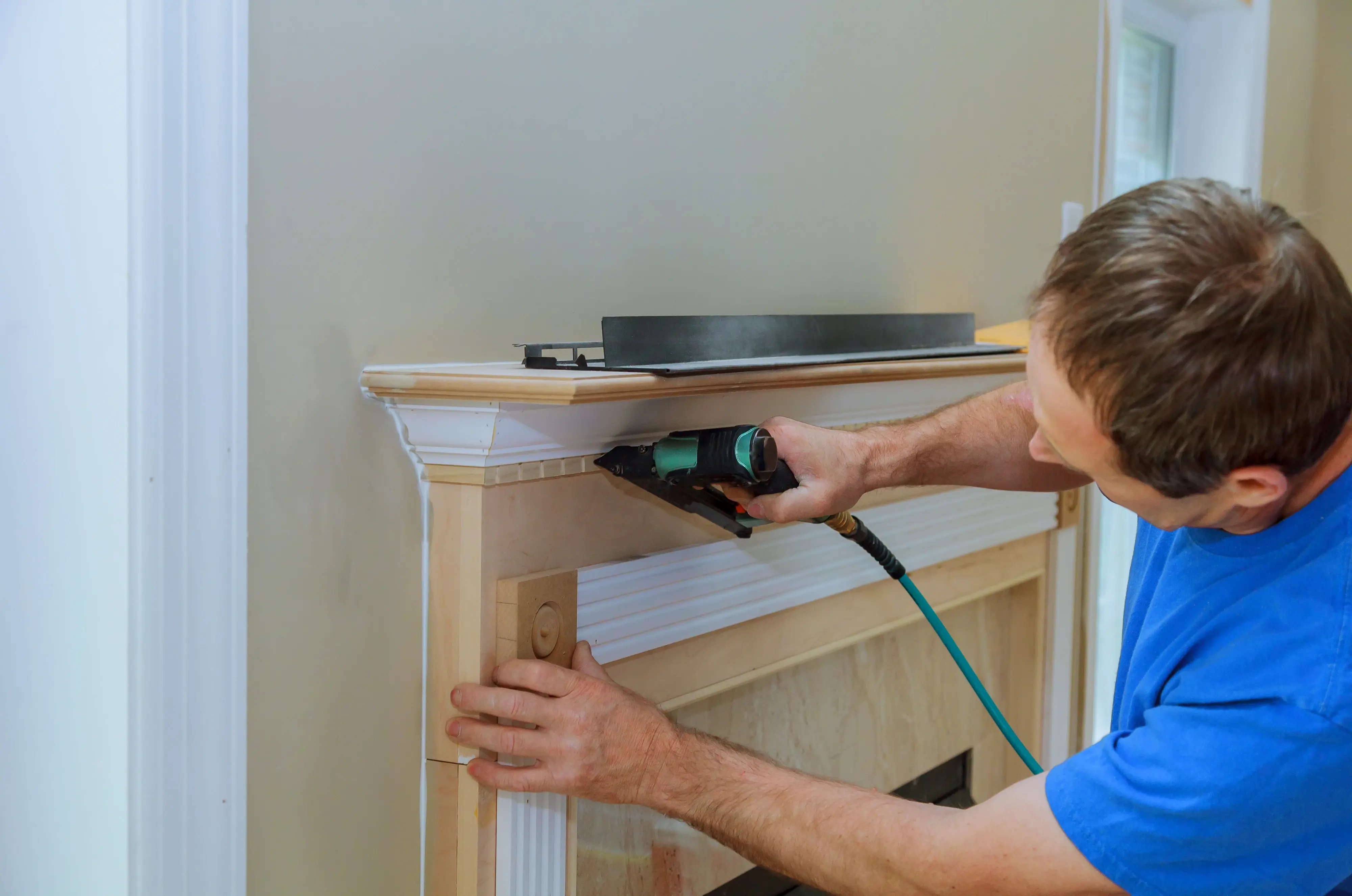 man working on fireplace mantel installation